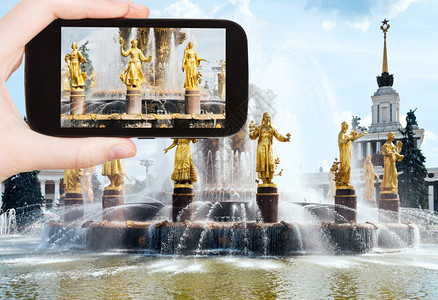 旅行概念游客在莫斯科全俄罗展览中心用智能手机拍摄不远友谊的照片图片