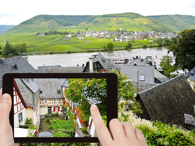 旅行概念旅游者用智能手机拍摄德国Moselle地区Beilstein村狭窄街道上的传统房屋图片