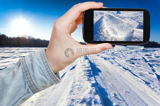 旅行概念旅游者用智能手机拍摄寒冬日雪田滑场赛的照片莫斯科图片