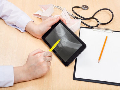 医生检查平板电脑上的人类膝关节X光照片图片