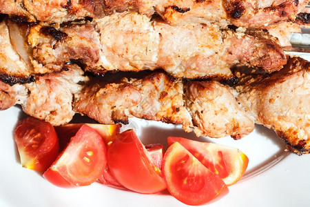红番茄片和盘子上切的红番茄和烤肉串图片