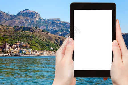 旅行概念在意大利西里市Taormina市和GiardiniNaxos海滩的Pc平板电脑上拍摄旅游照片用空白的屏幕剪切广告标志位置图片
