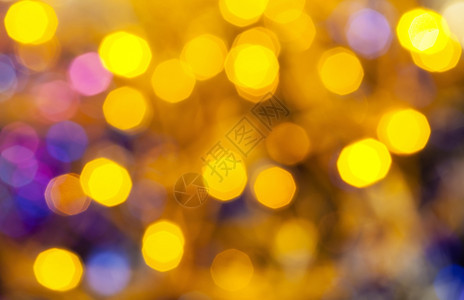 抽象的模糊背景Xmas树上电磨草地的黄蓝闪亮圣诞灯光图片