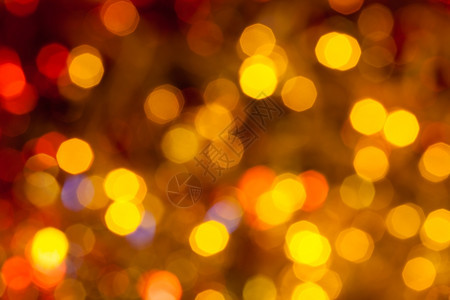 抽象的模糊背景Xmas树上电藻园的黑色褐黄和红交汇的圣诞灯光图片