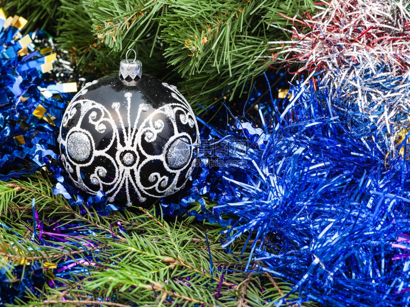 圣诞死寂生命一个黑色玻璃的圣诞舞会在Xmas树背景上的蓝锡罐图片