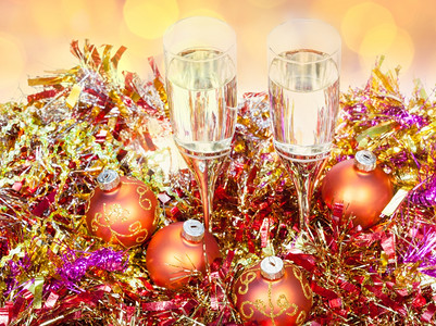 圣诞静生命在金色X马装饰品的两杯香槟上圣诞灯光模糊的背景图片