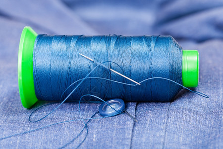 缝制静物生活针线蓝丝衣上的纽扣图片