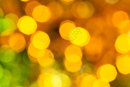 抽象的模糊背景在Xmas树上用电藻园布满的圣诞灯光照亮黄绿色深闪亮图片