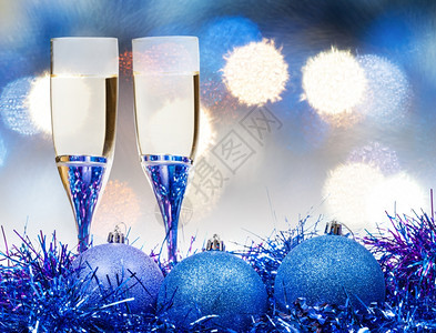 圣诞杯生命两香槟在蓝色的Xma装饰品上图片