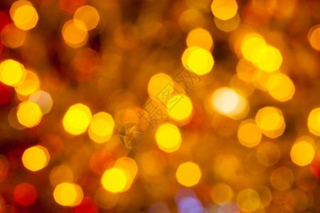 抽象的模糊背景深棕黄色和红闪亮的圣诞灯光在Xmas树上电藻园露出图片