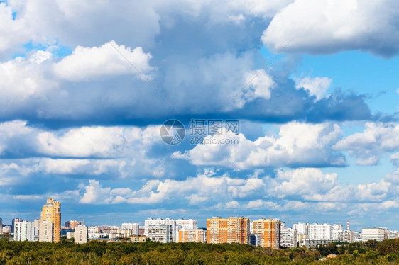 夏季绿林和公寓楼的低蓝云图片