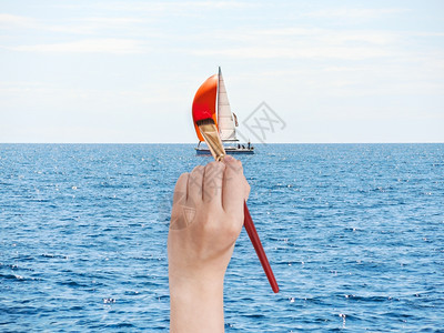 旅行概念手与油漆刷画蓝色亚得里海游艇红帆图片