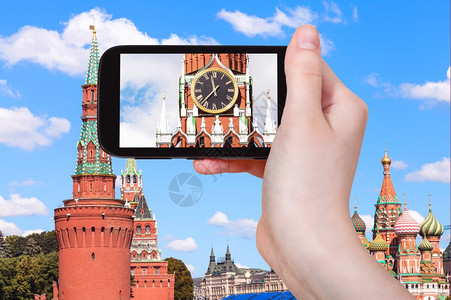 旅行概念在莫斯科克里姆林宫Spasskaya塔用智能手机拍摄时钟的旅游照片图片
