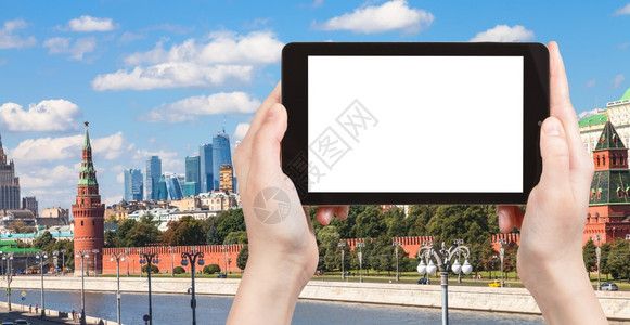 旅行概念手持平板电脑在背景上截断屏幕和莫斯科天线图片