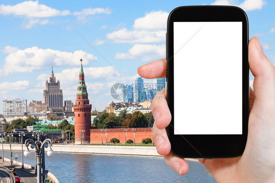 旅行概念手持智能机在背景上截断屏幕和莫斯科地标图片