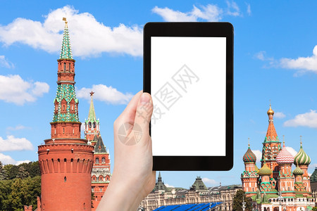 旅行概念手持平板电脑有剪掉的屏和莫斯科克里姆林宫塔的背景图片