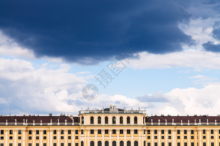 前往维也纳城市奥地利维也纳SchlossSchonbrunn宫殿上空蓝色天中的黑暗风暴云图片