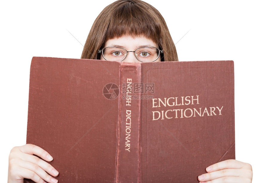 带着眼镜的女孩看英文字典本孤立在白色背景上图片