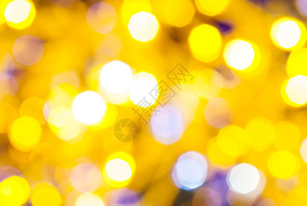 抽象的模糊背景浅黄色和紫闪烁着圣诞灯光在Xmas树上电藻园闪耀着光图片