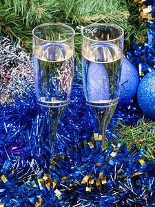 圣诞死寂生命两杯闪亮的红酒圣诞树背景的蓝色Xma装饰品图片