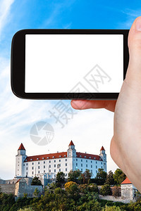 旅行概念智能手机上布拉迪斯发赫德城堡的旅游照片带有空白广告标志的屏图片