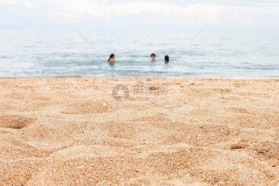 前景焦点沙滩和模糊游泳的人在海上的背景亚速海海岸线Temryuk湾Golubitskaya度假村塔曼半岛库班俄罗斯图片