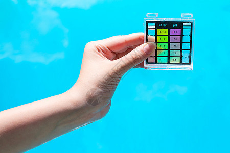 化学测试器量蓝色室外泳池的水污染图片