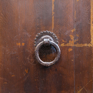 前往意大利佛罗伦萨市旧棕色门上的古铜环图片