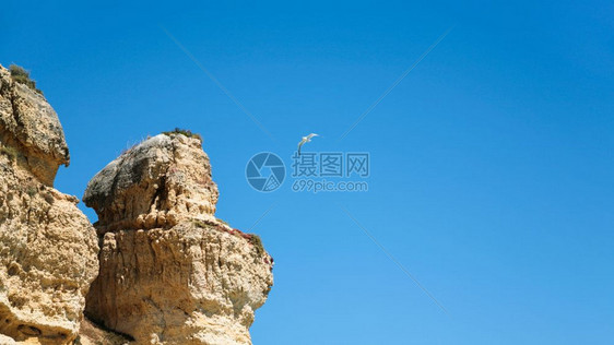 前往阿尔加夫葡萄牙侵蚀沙石岩与蓝天海鸥图片