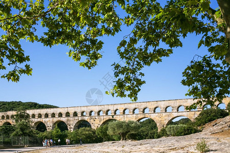 前往法国普罗旺斯游客通过VersPontduGard镇附近的Garddon河前往古罗马Gard水渠图片