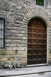 前往意大利冬季在佛罗伦萨市街上中世纪住宅门附近的自行车背景图片