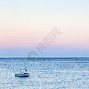 纳克索斯镇前往意大利西里蓝色和粉红夏季黄昏的GiardiniNaxos镇附近伊奥尼亚海蓝水上的船背景