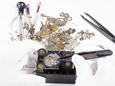 手表机械工用零件修理由白色背景的Tweezers修理图片