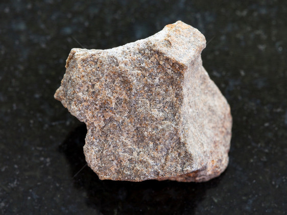 天然矿物岩石标本的大型深花岗岩背景上的粗石图片