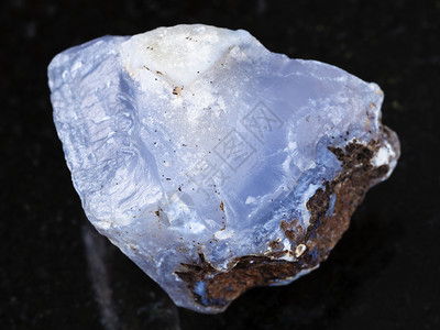 俄罗斯特兰斯贝卡利亚Zabaykalye天然矿物岩石标本的宏观拍摄深色花岗岩背景上蓝玉髓宝石的粗晶图片