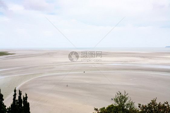 前往法国在诺曼底的LeMontSaintMichel岛附近的低潮泥湾上空图片