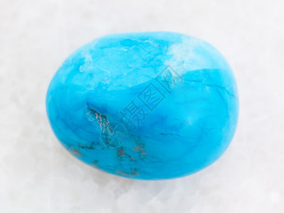 天然矿物岩石标本的大型白色大理石背景上的抛光Turquenite蓝色闪石宝图片