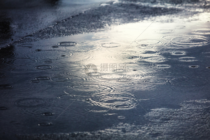 城里的一条人行道上有雨水图片