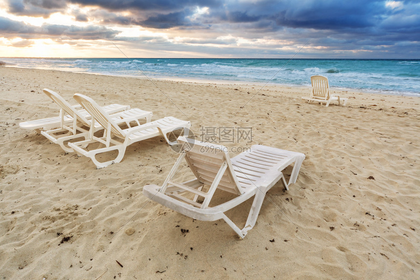 海洋背景沙滩上的甲板椅图片