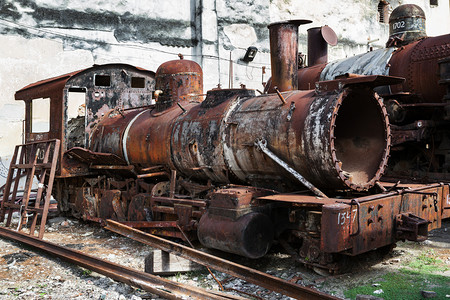 墙壁背景的老旧生锈蒸汽机车图片