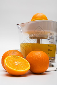 配有果汁和熟橙子的现代果汁提取器图片