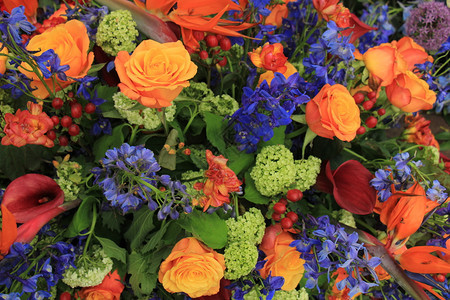 混合花安排不同橙色和蓝的婚礼花朵背景图片