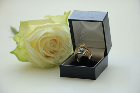 装在盒子和白玫瑰中的订婚戒指图片