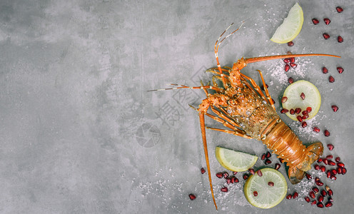 水泥背景的加柠檬和石榴蒸龙虾最佳景色新鲜龙虾海背景图片