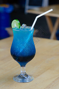 一杯蓝色意大利苏打水在咖啡厅的木桌上加石灰图片