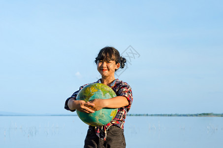 Asian女孩手握着自然界的球概念拯救世界女孩手握着球图片