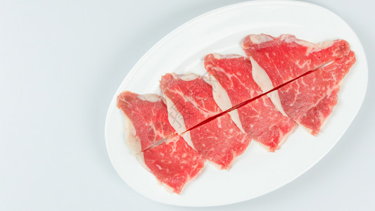 白色背景的盘子上一些生牛肉的顶部视图盘子上生牛肉的顶部视图图片