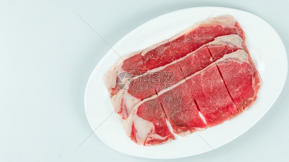 白色背景的盘子上一些生牛肉的顶部视图盘子上生牛肉的顶部视图图片