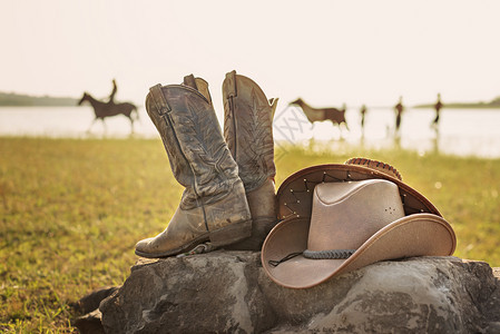 狂野西部复古牛仔帽和岩石上的旧皮靴狂野西部复古牛仔帽和靴子图片