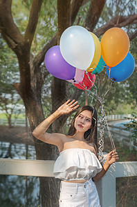 绿花园里有气球的亚洲漂亮女人肖像图片